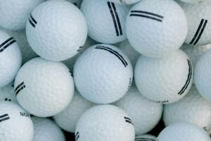 A detailed close-up shot of a pile of golf balls, perfect for sports themes. Ideal for golf enthusiasts.